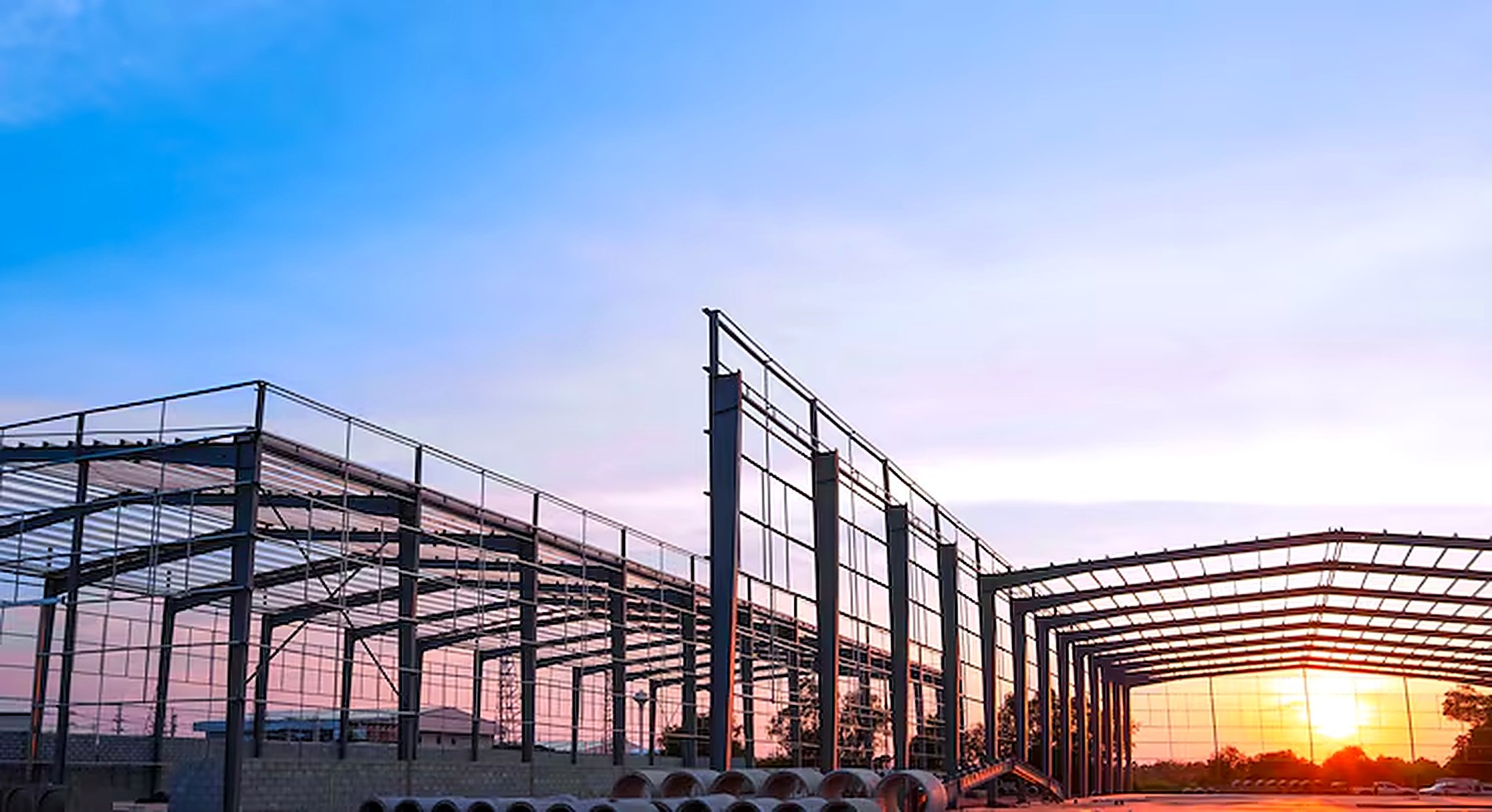 Steel structure under construction at sunset